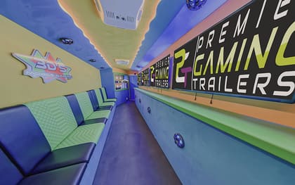 Inside the 3DS Mobile Gaming trailer: the owner's own star-shaped sign on the left wall above green benches, with PGT screens running the length of the right
