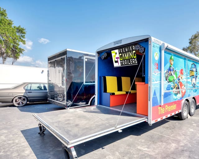 A Gamers Utopia from the rear with the ramp down, showing quilted benches and a screen inside, and the wrap running across the rear doors