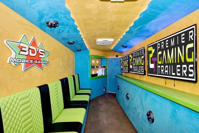 Inside a Gamers Utopia: lime and black quilted benches on the left, a yellow wall with a star logo, a blue ceiling edged with LED light, PGT screens above a lime counter on the right and a lit control niche at the far end